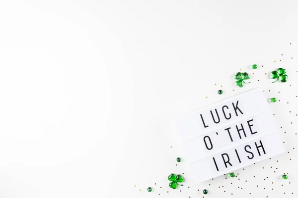 Lightbox with Saint Patricks day greeting and shamrocks of green glass hearts — Stock Photo, Image
