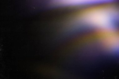 Renkli sıcak gökkuşağı ışığı toz desenli siyah arkaplanda sızar