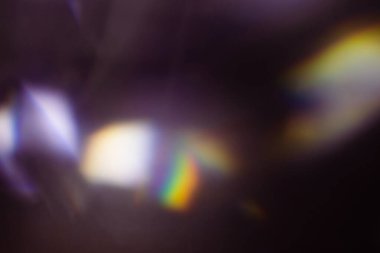 Renkli sıcak gökkuşağı ışığı toz desenli siyah arkaplanda sızar