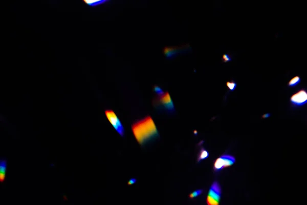 Kolorowe ciepłe tęczowe kryształowe światło przecieka na czarnym tle — Zdjęcie stockowe