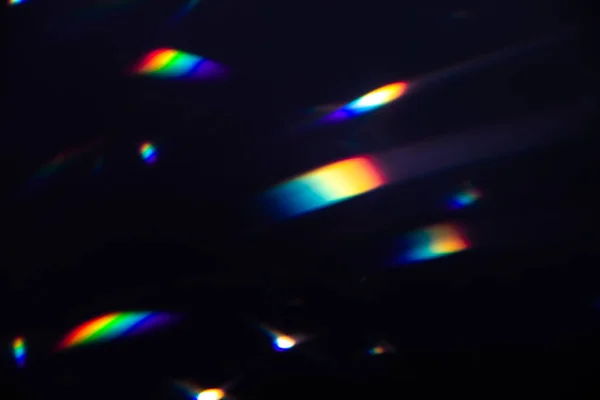 Colorful warm rainbow crystal light leaks on black background — Stock Photo, Image