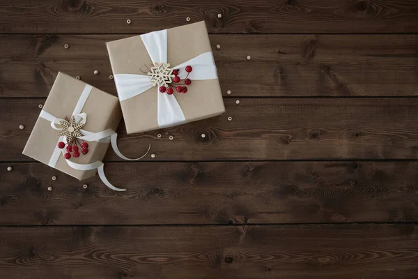 Kerst achtergrond met twee geschenkdozen op donkerbruine houten achtergrond — Stockfoto