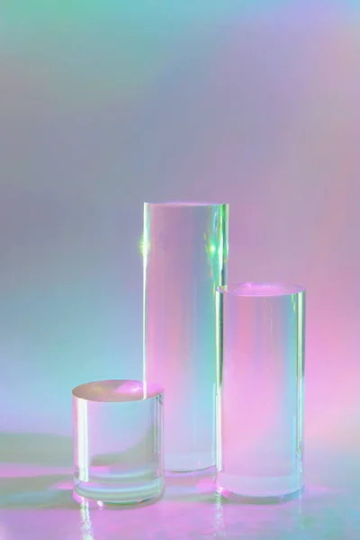 Tres podios de cilindro de vidrio transparente sobre fondo holográfico de color pastel —  Fotos de Stock