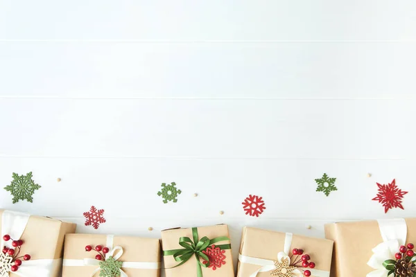 Περίγραμμα των κιβωτίων δώρου τυλιγμένο σε χαρτί Kraft σε λευκό φόντο γραφείο ξύλο — Φωτογραφία Αρχείου