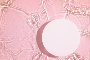Şeffaf pembe berrak su arka planında boş beyaz daire podyumu