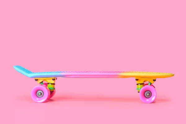 Szivárvány műanyag Penny board gördeszka elszigetelt rózsaszín háttér — Stock Fotó