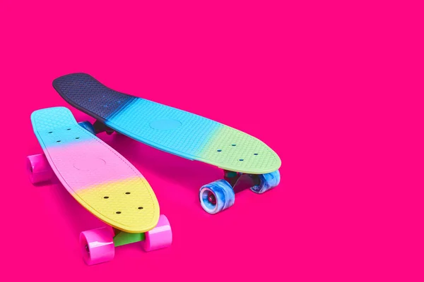 Két szivárvány műanyag Penny board gördeszka bíbor háttér — Stock Fotó