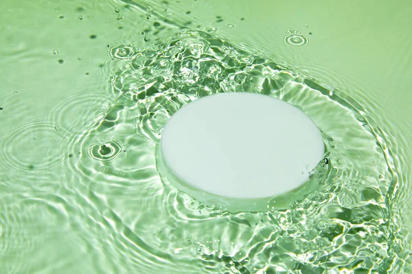 Empty white circle podium on transparent green clear water background