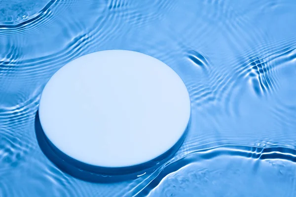 Порожній подіум білого кола на прозорому темно-синьому фоні води — стокове фото