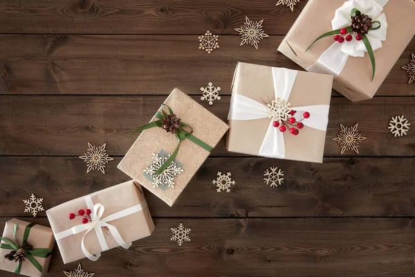 Kerst achtergrond met rand van geschenkdozen op donkerbruine houten achtergrond — Stockfoto