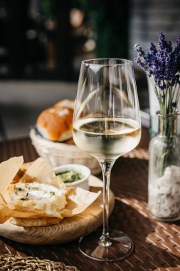 Bir bardak soğuk beyaz şarap ve fırında kamembert peyniri.