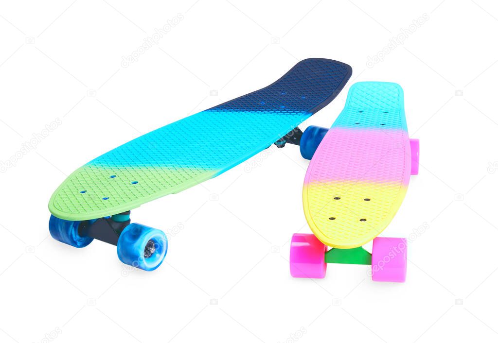 Two rainbow plastic Penny board skateboards on white background