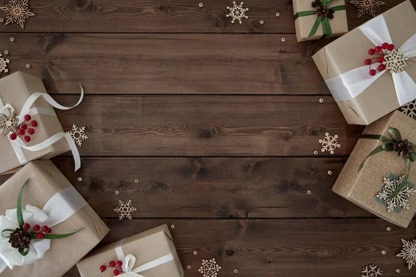 Kerst achtergrond met randen van geschenkdozen op donkerbruine houten achtergrond — Stockfoto