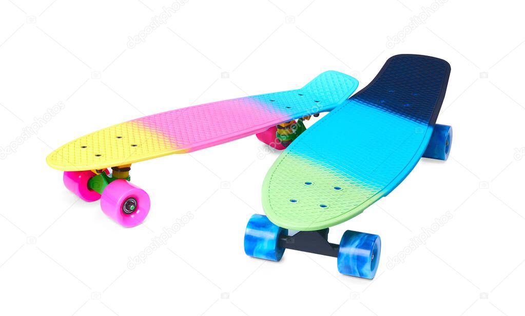 Two rainbow plastic Penny board skateboards on white background