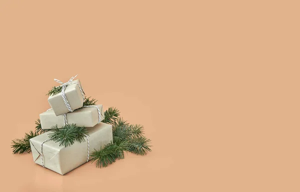 Χριστουγεννιάτικα κουτιά δώρων και έλατο σε μπεζ φόντο — Φωτογραφία Αρχείου
