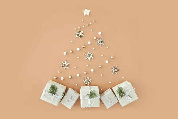 Árvore de Natal feita de pequenos presentes no fundo bege — Fotografia de Stock
