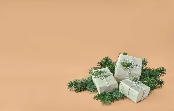 Weihnachtsgeschenkboxen und Tanne auf beigem Hintergrund — Stockfoto