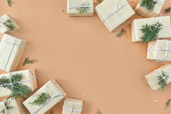 Noel hediye kutuları ve bej arka planda köknar ağacı — Stok fotoğraf
