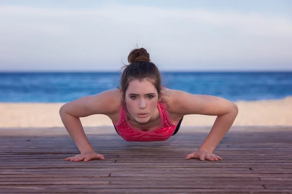 Fit žena dělá push up nebo stiskněte navigační tlačítko nahoru — Stock fotografie