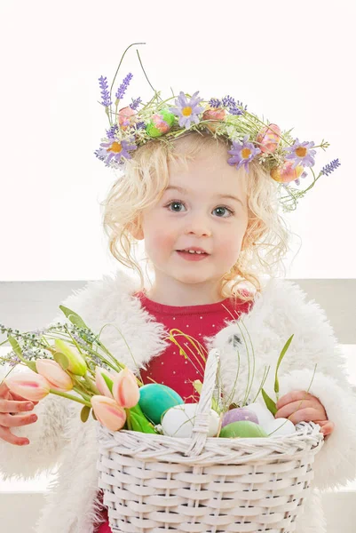 幸せな笑顔イースター卵狩り女の子とともに花 ロイヤリティフリーのストック写真