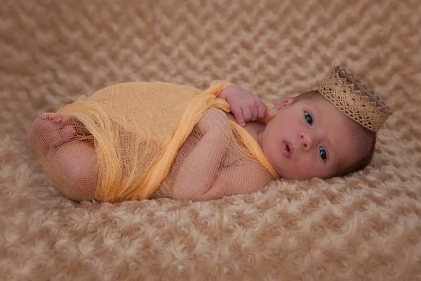 Baby wrapped in muslin with crown — Stock Photo, Image