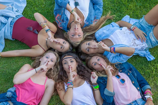 Group of teens fingers to lips for suprise secret. — Stock Photo, Image