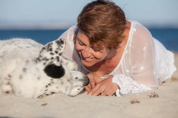 Liebevolle Hundehalterin am Strand — Stockfoto