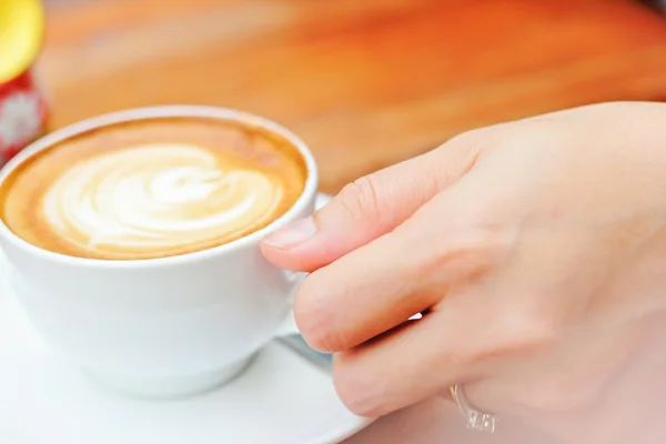 Frauenhand mit einer weißen Tasse Kaffee — Stockfoto