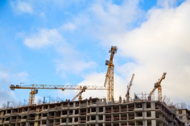 Yeni bir mahallede vinçleri olan apartmanlar inşa ediliyor. Yatay olarak..