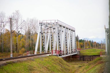 Sonbahar doğasının arka planında demiryolu köprüsü. Yatay olarak.