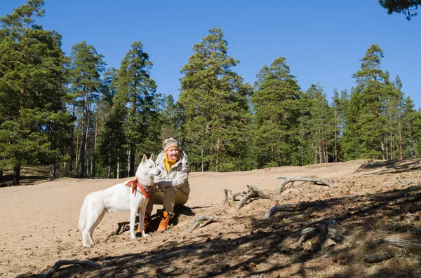 Die Frau mit einem weißen Hund im Wald — Stockfoto