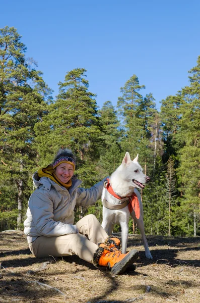 La donna con un cane bianco in un bosco — Foto Stock