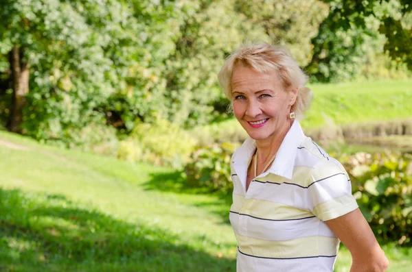 Portrait of a middle-aged woman in a park on a sunny day — Stock Photo, Image