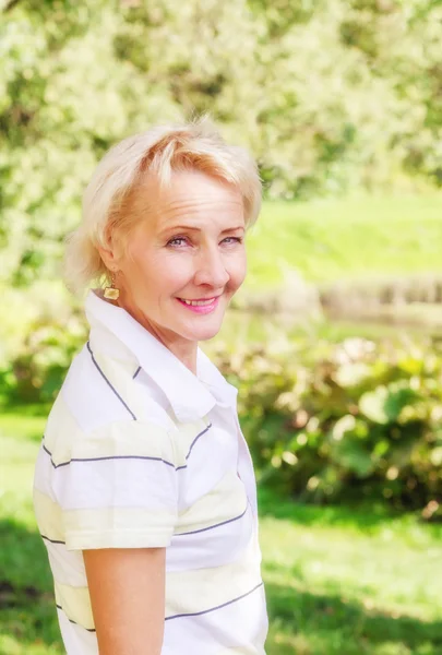 Portrait of a middle-aged woman in a park on a sunny day — Stock Photo, Image