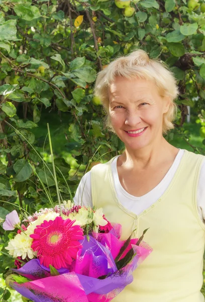 Portrait of a woman in the garden with a bouquet of flowers — Stock Photo, Image