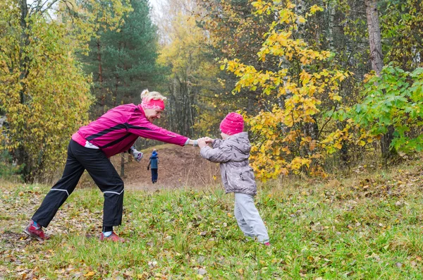 Kvinne med jente som gjør aerobic i høstparken – stockfoto