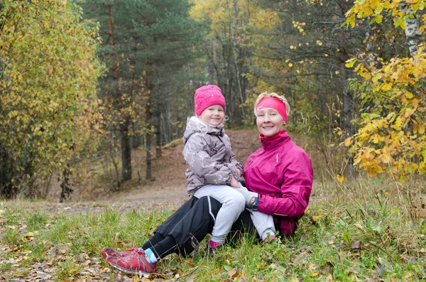 Grandmother with her granddaughter in the autumn park — Stock Photo, Image