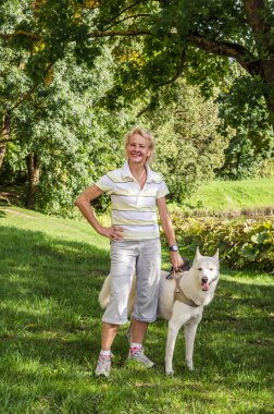 Parkta bir yürüyüş üzerinde bir köpekle kadın