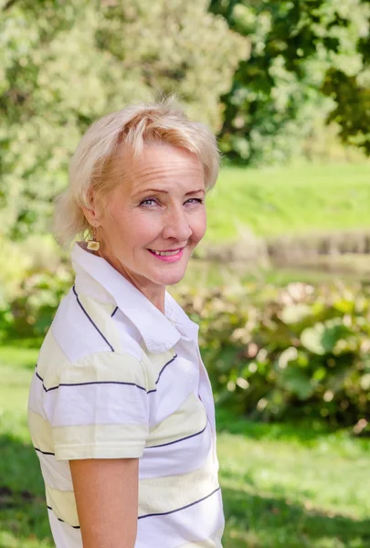 Portrait of a middle-aged woman in a park on a sunny day — Stock Photo, Image