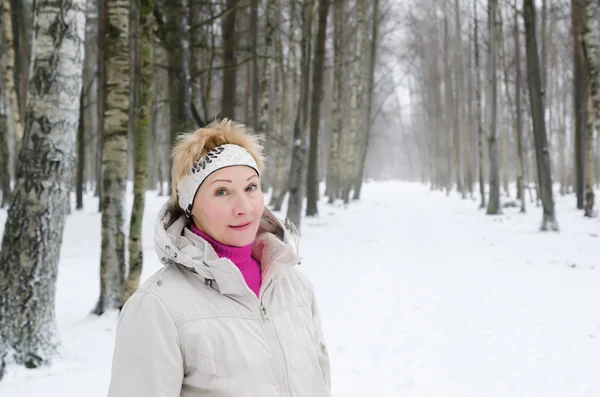Bir kış al arka plan üzerinde orta yaşlı bir kadın portresi — Stok fotoğraf