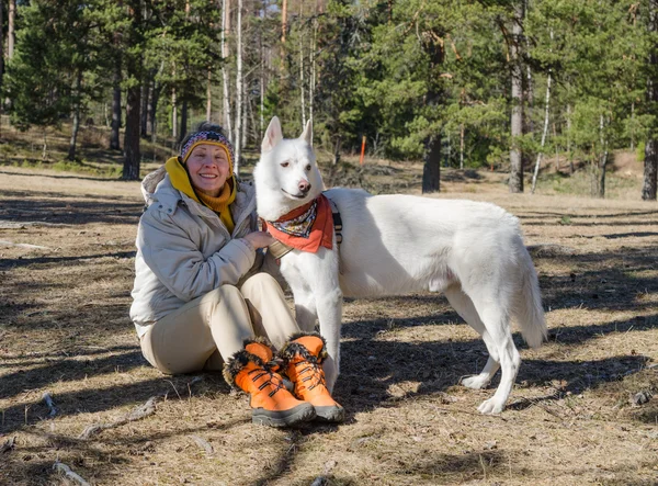 Frau mit weißem Hund im Wald — Stockfoto