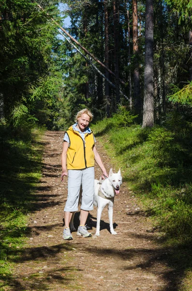 Женщина с собакой на прогулке в парке — стоковое фото