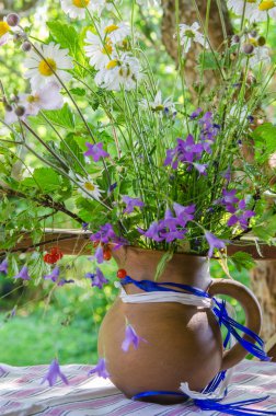 Bahçede bir masaya yaz çiçek bir buket ile sürahi