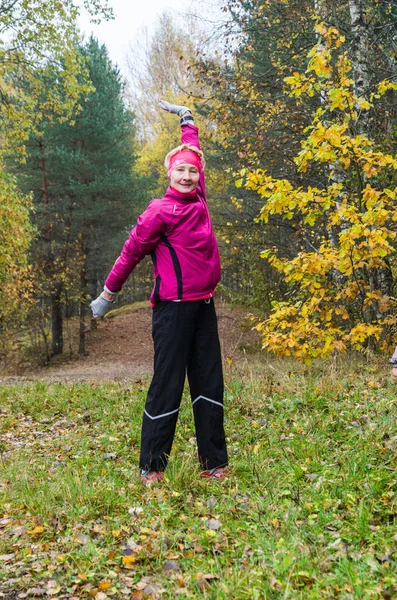 Wman is engaged in aerobics in the autumn park — Stock Photo, Image