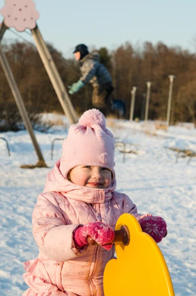 Children swinging on a swing in winter — Stock Photo, Image