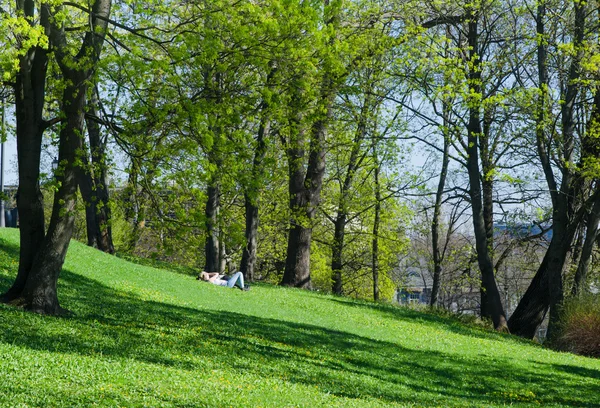Jonge mensen ontspannen in het park op het gras — Stockfoto