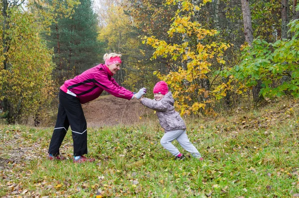 Kvinne med jente som gjør aerobic i høstparken – stockfoto