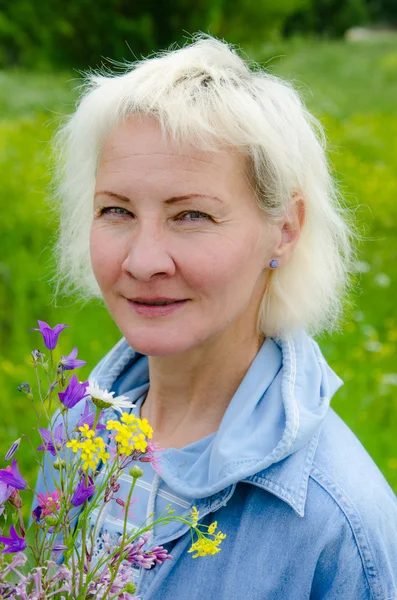 Porträtt av kvinna med en bukett av blommor i handen — Stockfoto