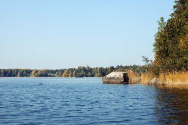 Adanın kıyısındaki sudan büyük bir taş fırlıyor.