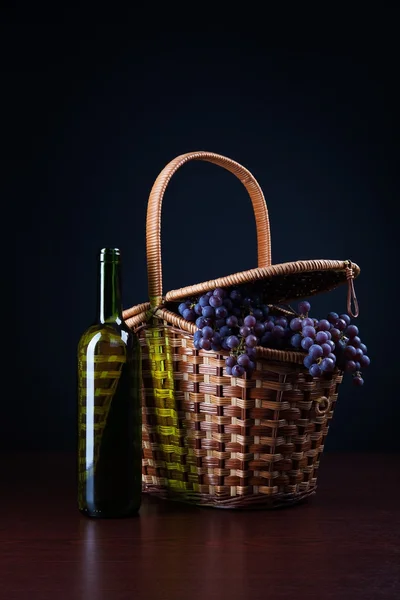 Bottle of wine and basket with grapes